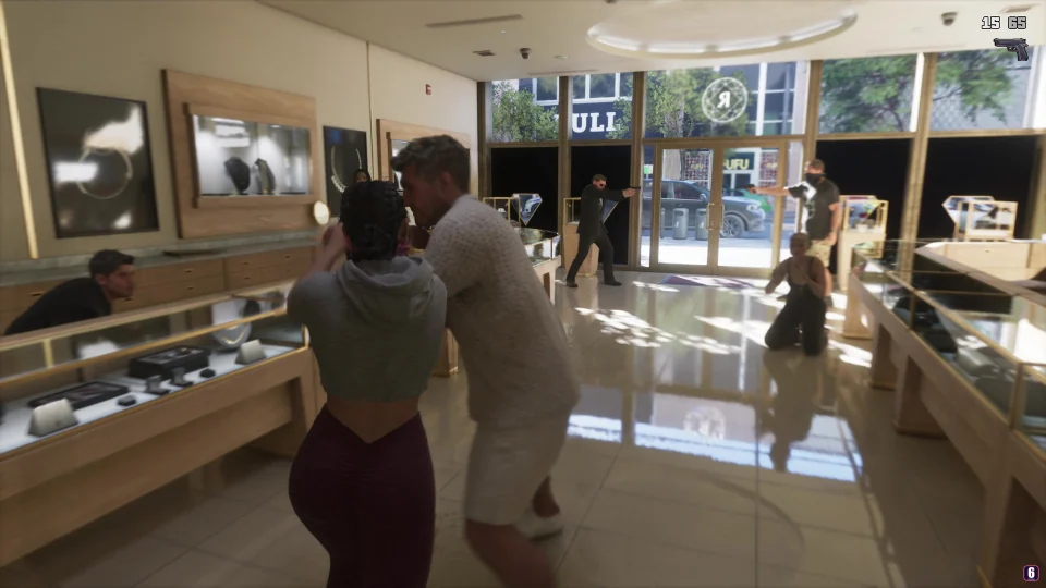 Lucia se enfrenta a alguien cuerpo a cuerpo en una joyería mientras Jason encañona a una persona junto a la entrada