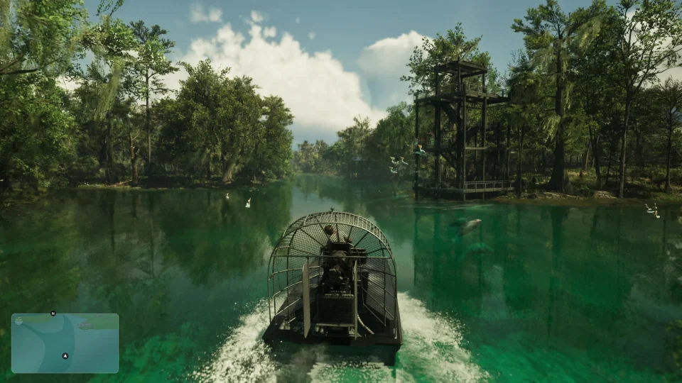 Ein Airboat fährt auf grünem Wasser zwischen Sumpfbäumen und einem Holzturm hindurch