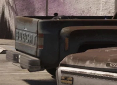 Close crop of the parking lot showing BOBCAT on a separate pickup's tailgate