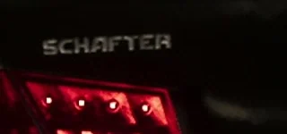Close crop of the original frame showing SCHAFTER on the sedan's trunk