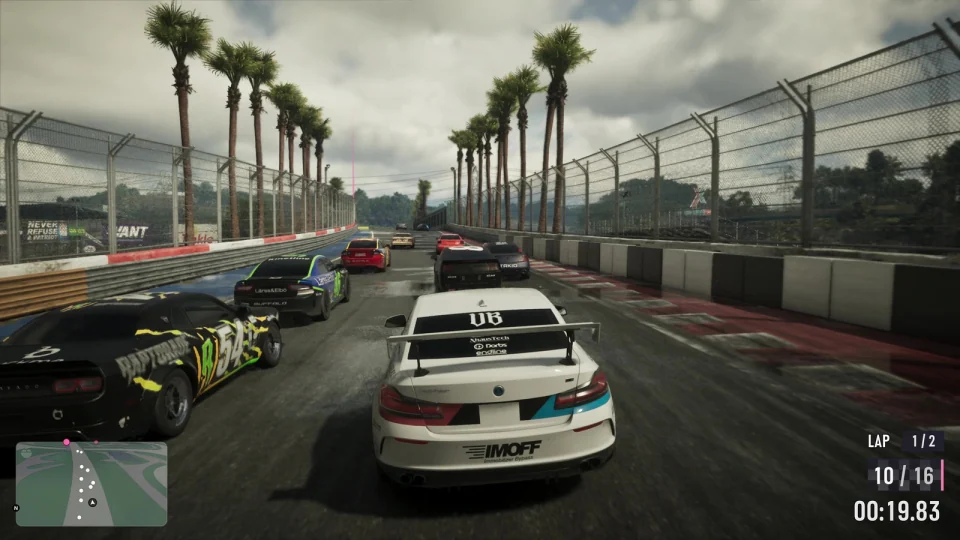 Race-liveried coupe with a wing among other cars on a circuit