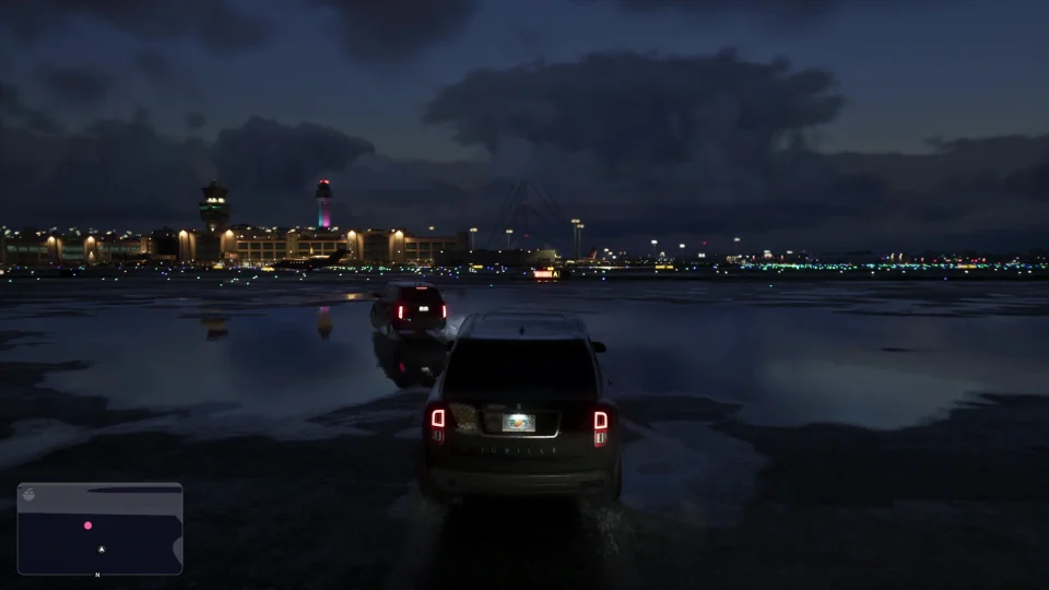 SUV driving across a wet airport apron at night, seen from behind