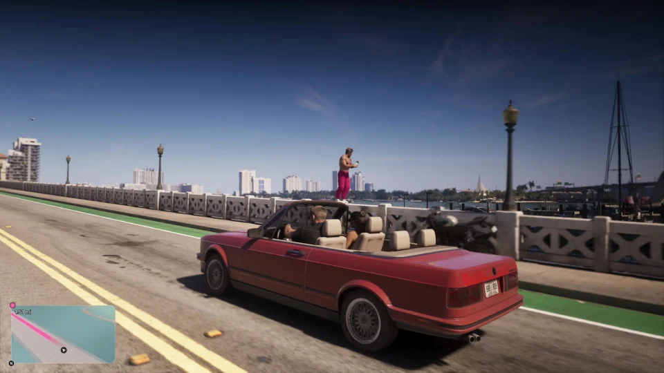 Angular red convertible with its roof down driving across a bridge